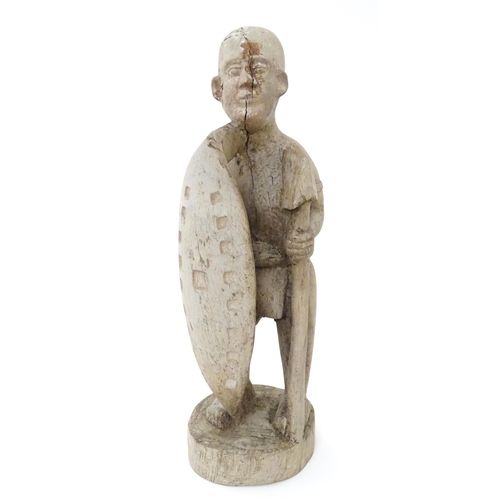 893 - Ethnographic / Native / Tribal: An African carved wood figure with a shield and spear. Approx. 17