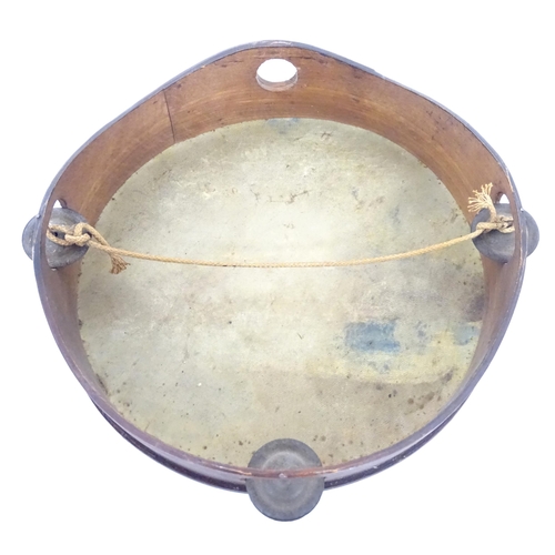 897 - A 20thC tambourine, the drum painted in oils depicting a Continental lake scene with fisherman, boat... 