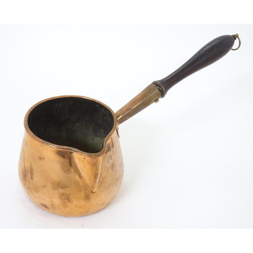 900 - A 19thC copper saucepan with spout and turned wooden handle. Approx. 14 1/4