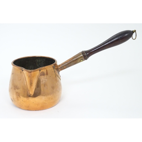 900 - A 19thC copper saucepan with spout and turned wooden handle. Approx. 14 1/4