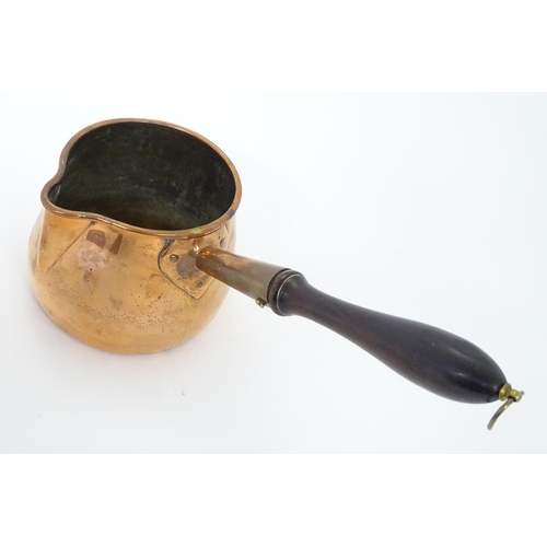 900 - A 19thC copper saucepan with spout and turned wooden handle. Approx. 14 1/4