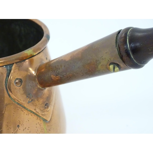 900 - A 19thC copper saucepan with spout and turned wooden handle. Approx. 14 1/4