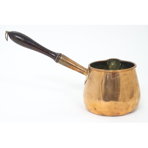 900 - A 19thC copper saucepan with spout and turned wooden handle. Approx. 14 1/4