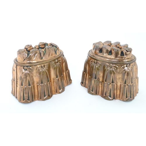 900A - Two Victorian copper jelly moulds, the sides with reeded columns and floral decoration surmounted by... 