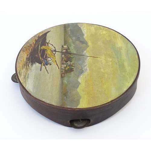 897 - A 20thC tambourine, the drum painted in oils depicting a Continental lake scene with fisherman, boat... 