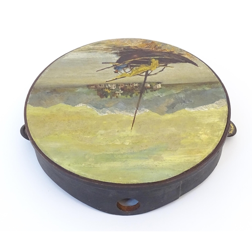 897 - A 20thC tambourine, the drum painted in oils depicting a Continental lake scene with fisherman, boat... 