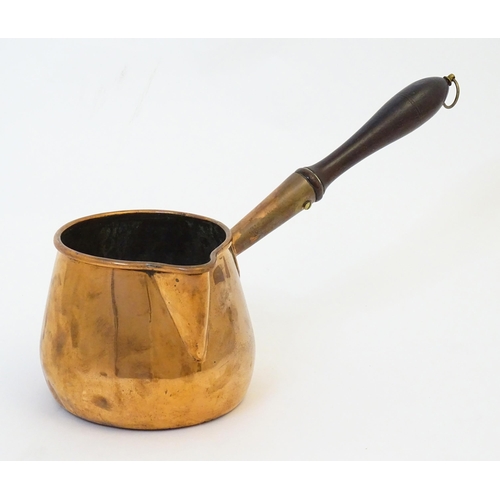 900 - A 19thC copper saucepan with spout and turned wooden handle. Approx. 14 1/4