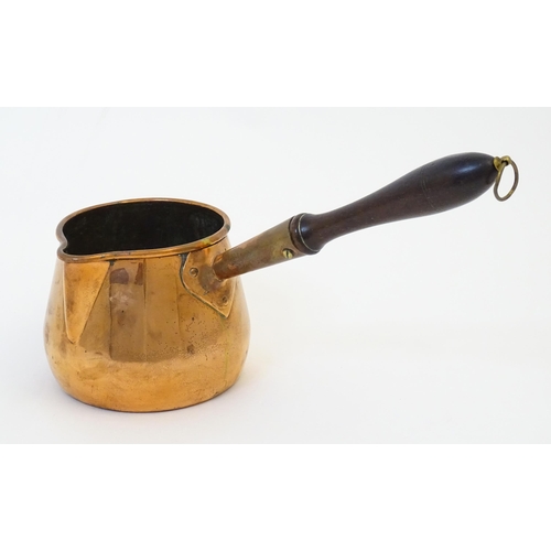 900 - A 19thC copper saucepan with spout and turned wooden handle. Approx. 14 1/4