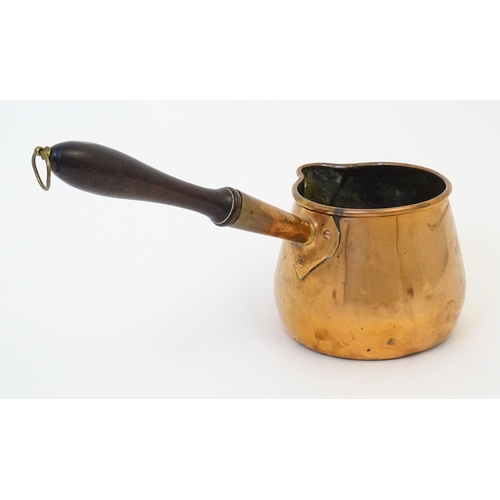 900 - A 19thC copper saucepan with spout and turned wooden handle. Approx. 14 1/4