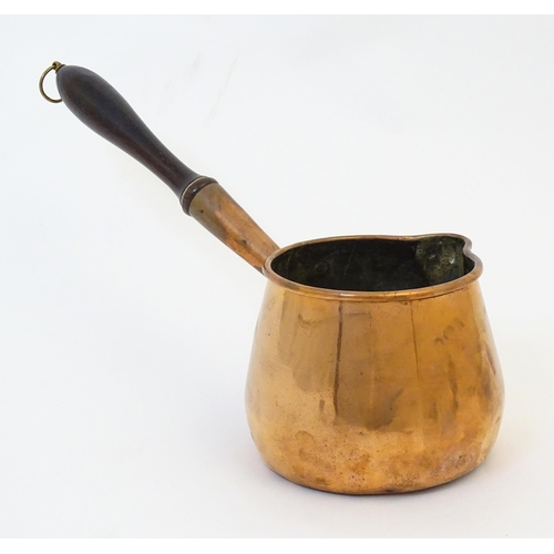 900 - A 19thC copper saucepan with spout and turned wooden handle. Approx. 14 1/4