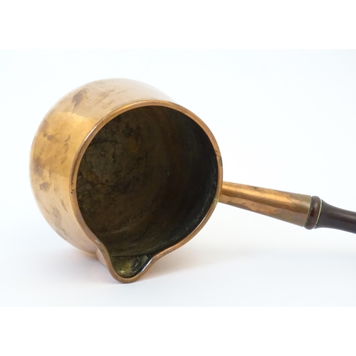 900 - A 19thC copper saucepan with spout and turned wooden handle. Approx. 14 1/4