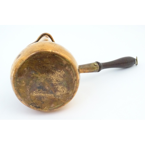 900 - A 19thC copper saucepan with spout and turned wooden handle. Approx. 14 1/4