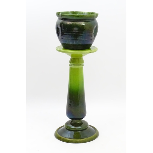 182 - A late 19th / early 20thC Bretby jardiniere / planter on stand with a green glaze. Stand stamped 143... 