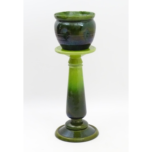 182 - A late 19th / early 20thC Bretby jardiniere / planter on stand with a green glaze. Stand stamped 143... 