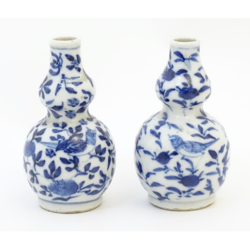 48 - A pair of small Chinese blue and white double gourd vases decorated with birds, flowers and foliage.... 