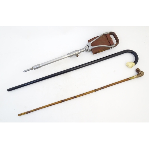 885 - Two 20thC walking sticks / canes comprising an ebonised walking stick the handle modelled as a boxer... 