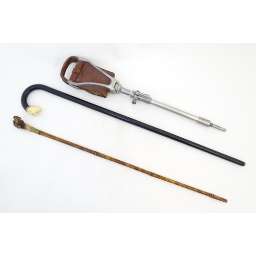 885 - Two 20thC walking sticks / canes comprising an ebonised walking stick the handle modelled as a boxer... 