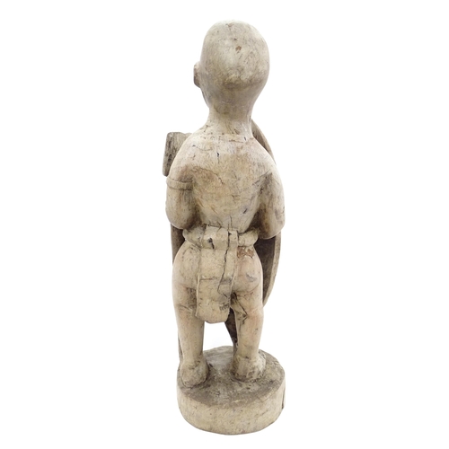 893 - Ethnographic / Native / Tribal: An African carved wood figure with a shield and spear. Approx. 17