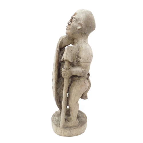 893 - Ethnographic / Native / Tribal: An African carved wood figure with a shield and spear. Approx. 17