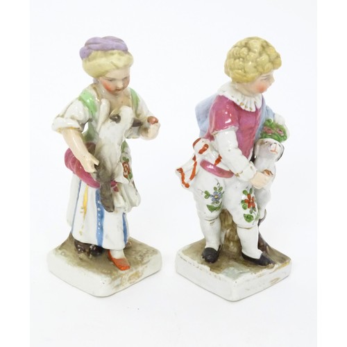 12 - A pair of Continental porcelain figurines, one modelled as a girl with a cat, the other modelled as ... 