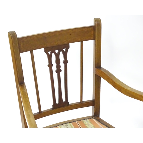 27 - A pair of early 20thC mahogany elbow chairs with satinwood cross banded frames and pierced back spla... 