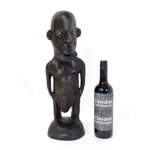 45 - Ethnographic / Native / Tribal: An African carved hardwood figure with inlaid eyes and carved decora... 