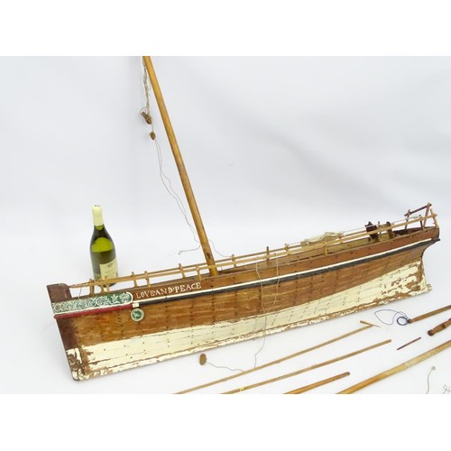 69 - A model of a sail boat, the hull titled Love and Peace. Approx 48