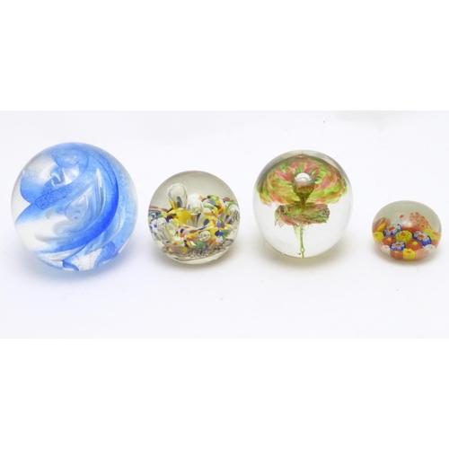 39 - Four assorted glass paperweights. The largest approx 3 1/2