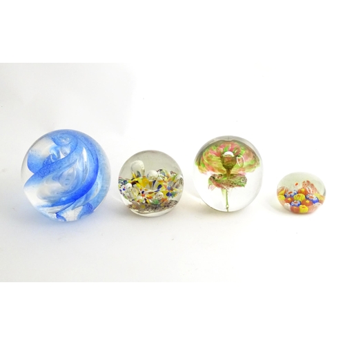 39 - Four assorted glass paperweights. The largest approx 3 1/2