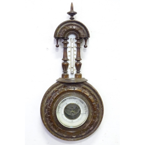 71 - An aneroid barometer / thermometer within a carved wooden surround. Approx 16