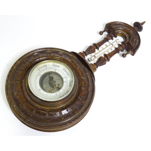 71 - An aneroid barometer / thermometer within a carved wooden surround. Approx 16