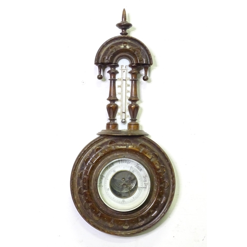 71 - An aneroid barometer / thermometer within a carved wooden surround. Approx 16