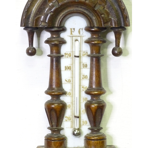 71 - An aneroid barometer / thermometer within a carved wooden surround. Approx 16