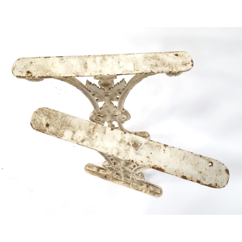 48 - A pair of cast and white painted table support with floral and thistle detail, bearing marks for H. ... 