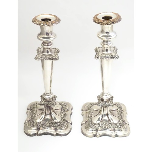 942 - A pair of silver plate candlesticks with acanthus scroll and floral decoration Approx 12