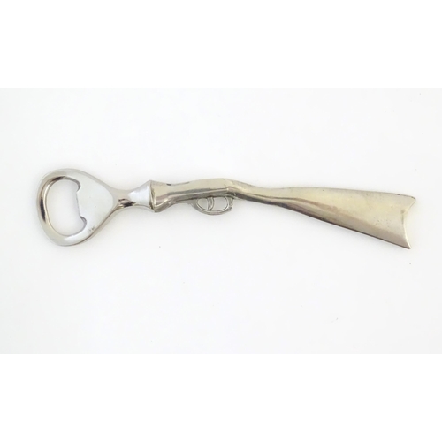 948 - A boxed silver plated bottle opener, the handle formed as a the stock and action of a shotgun, appro... 