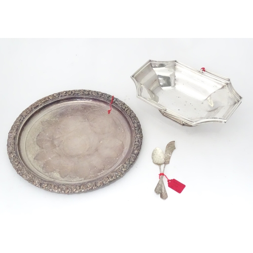 957 - Assorted silver plated wares to include a cake basket, butter knife, preserve spoon, and a circular ... 