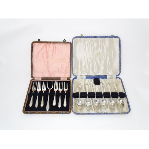 951 - A cased set of silver plate cake forks and served together with a cased set of six silver plated spo... 