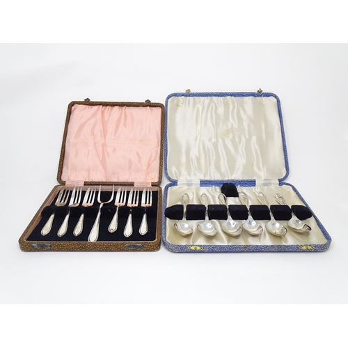 951 - A cased set of silver plate cake forks and served together with a cased set of six silver plated spo... 