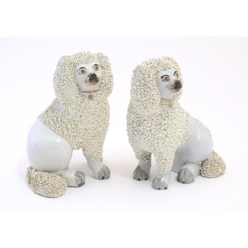 56 - A pair of Staffordshire pottery models of seated Poodle dogs with gilded collars. Approx. 5 1/2