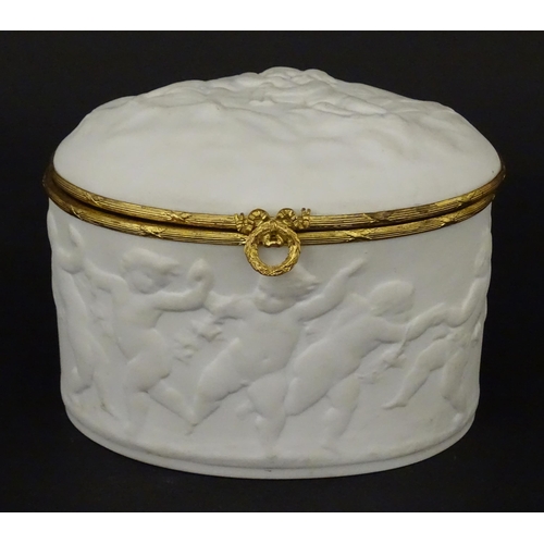 71 - A Limoges parian ware oval box with a hinged lid, decorated in relief with dancing putti / cherubs. ... 