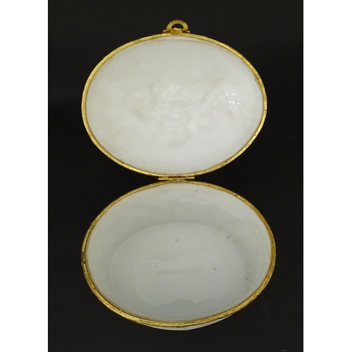 71 - A Limoges parian ware oval box with a hinged lid, decorated in relief with dancing putti / cherubs. ... 