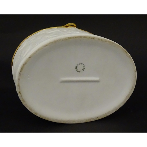 71 - A Limoges parian ware oval box with a hinged lid, decorated in relief with dancing putti / cherubs. ... 