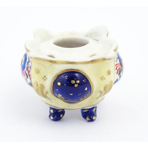 73 - A Continental porcelain inkwell of shaped form with floral and foliate detail and gilt highlights. A... 