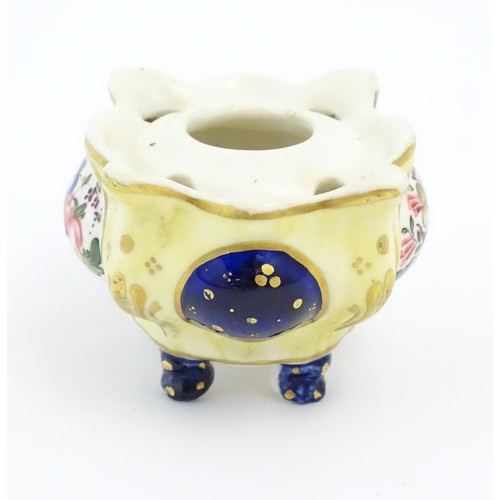 73 - A Continental porcelain inkwell of shaped form with floral and foliate detail and gilt highlights. A... 