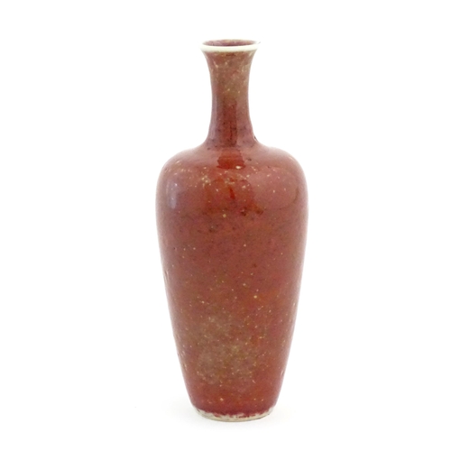 20 - A Chinese vase of tapering baluster form with a red glaze. Character marks under. Approx. 8