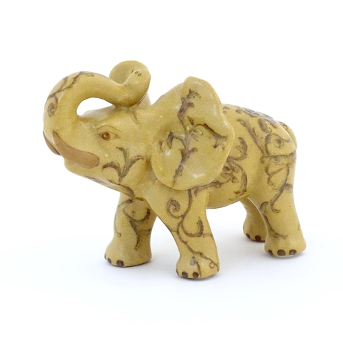 74 - An Oriental ceramic model of an elephant with painted detail. Marked under. Approx. 7