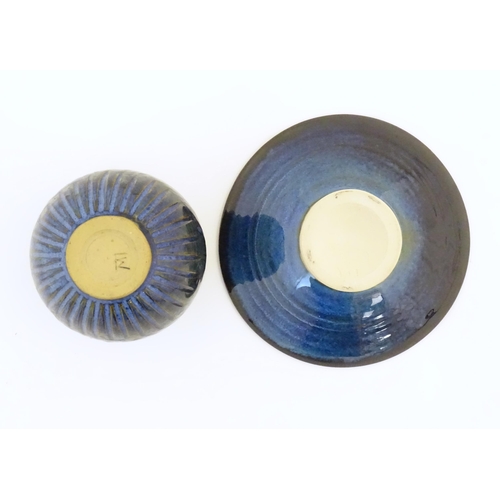 76 - Two items of studio pottery comprising a footed bowl of tapering form with a blue glaze, incised LW ... 