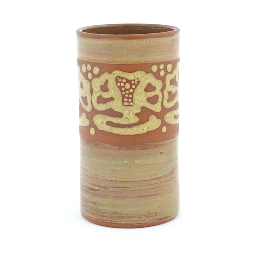 78 - A terracotta studio pottery vase of cylindrical form with banded slip decoration. Signed under. Appr... 