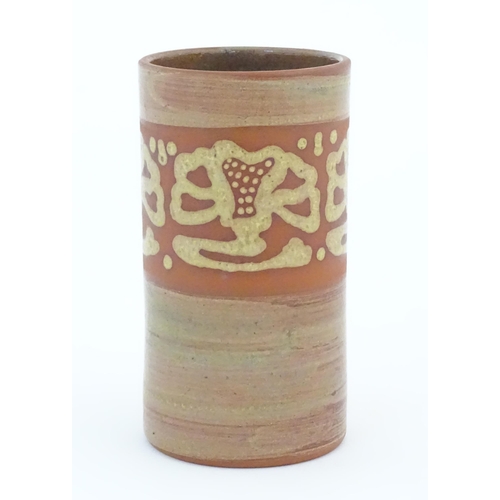 78 - A terracotta studio pottery vase of cylindrical form with banded slip decoration. Signed under. Appr... 